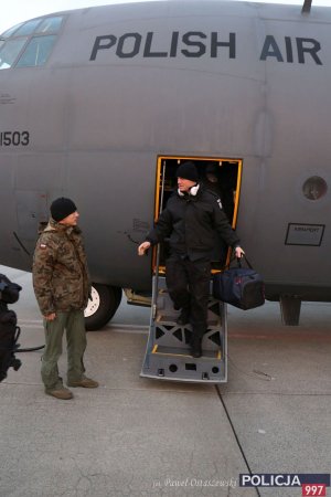 Płyta lotniska, policjant wysiada z samolotu