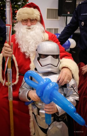 Dziecko przebrane za postać z Gwiezdnych Wojen robi sobie zdjęcie ze św. Mikołajem