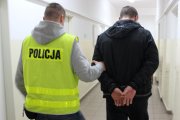 policjant prowadzi zatrzymanego