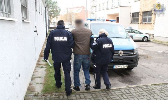 policjanci prowadzą zatrzymanego