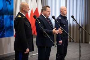 Wiceminister SWiA Jarosław Zieliński podczas briefingu wraz z Komendantem Głównym Policji gen.insp. Jarosławem Szymczykiem oraz Komendantem Głównym Państwowej Straży Pożarnej gen. bryg. Leszek Suskim. Przemawia wiceminister.