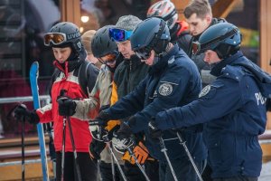 Kręcie mnie bezpieczeństwo na stoku - Kasina - policjanci ustawiają się by usiąść na ławeczce wyciągu