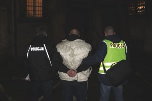 Policjanci prowadzą zatrzymanego