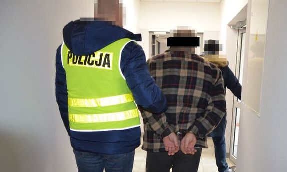 policjant prowadzi zatrzymanego mężczyznę