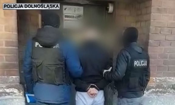 policjanci prowadzą zatrzymanego