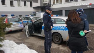 mały chłopiec z policjantem i matką przy radiowozie policyjnym