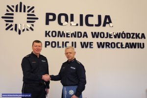 Asp. szt. Paweł Petrykowski i nadkom. Krzysztof Zaporowski. W tle napis: Komenda Wojewódzka Policji we Wrocławiu