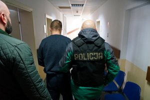 policjanci prowadzą zatrzymanego