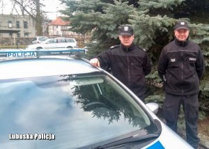 dwaj policjanci przy radiowozie