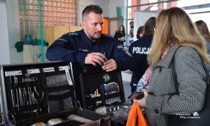 policjant pokazuje kobiecie sprzęt policyjny