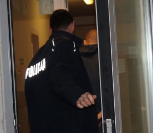 policjant prowadzi zatrzymanego