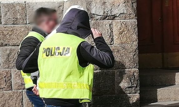 Policjanci prowadzą zatrzymanego.