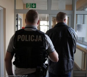 policjant prowadzi zatrzymanego