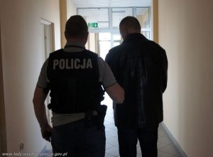 policjant prowadzi zatrzymanego