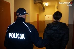 policjant prowadzi zatrzymanego