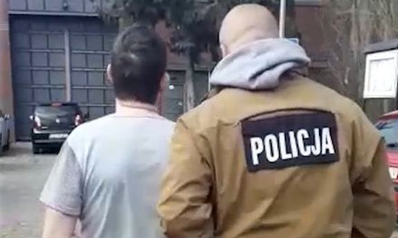 policjant prowadzi zatrzymanego