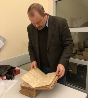 Koordynator ds. zabytków KWP w Szczecinie  przegląda księgę
