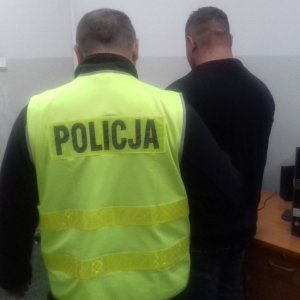 policjant prowadzi zatrzymanego