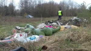 policjant na nielegalnym wysypisku śmieci