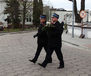 dwaj żołnierze niosą wieniec kwiatów