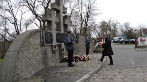 dwaj policjanci na warcie przy Pomniku Pamięci w Trojanowie, mężczyzna składa kwiaty