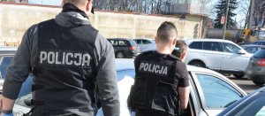 na zdjęciu policjant, a zatrzymany mężczyzna wsiada do radiowozu