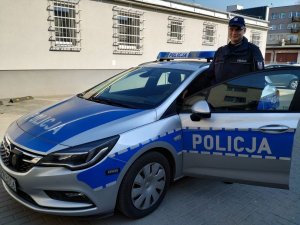 policjant przy otwartym radiowozie