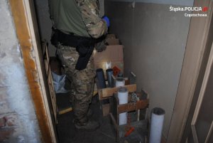policjant zabezpiecza znalezione materiały wybuchowe