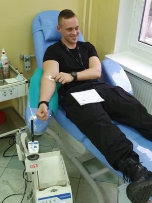 Młody policjant ze Szkoły Policji w Słupsku oddaje krew na fotelu w Centrum Krwiodawstwa i Krwiolecznictwa w Słupsku.