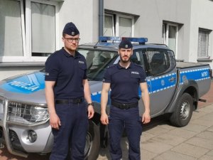 dwaj policjanci w mundurach, w tle radiowóz