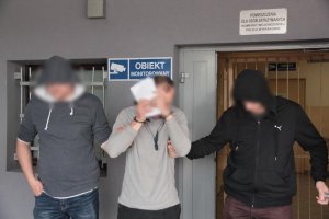 dwaj policjanci prowadzą zatrzymanego mężczyznę