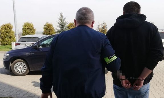 policjant prowadzi zatrzymanego mężczyznę