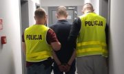 dwaj policjanci prowadzą zatrzymanego mężczyznę