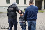 policjanci prowadzą zatrzymanego