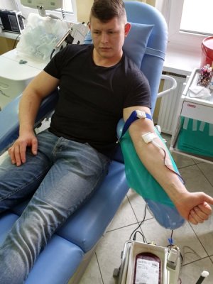 Policjant na fotelu oddaje krew.
