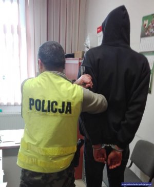 policjant prowadzi zatrzymanego mężczyznę