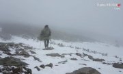 Obrazek przedstawia mężczyznę, który idzie po górach, w bardzo niekorzystnych warunkach, wszędzie śnieg