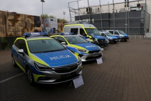 policyjne radiowozy na placu przed budynkiem targów