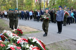 podinsp. Horosz składa kwiaty przed tablicą pamiątkową