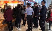 polscy i czescy policjanci podczas wspólnego patrolu w centrum handlowym rozmawiają z kobietą i mężczyzną