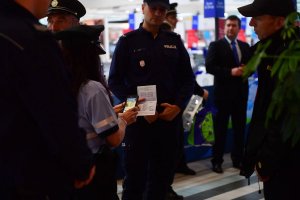 polscy i czescy policjanci podczas wspólnego patrolu w centrum handlowym kontrolują dokumenty mężczyzny