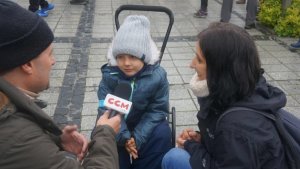 zdjęcie przedstawia chłopca na wózku inwalidzkim po prawej stronie jego mamę, a po lewej dziennikarza z radia CCM trzymającego przed chłopcem  mikrofon