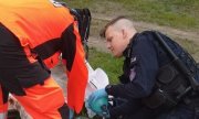 policjant z II Kompani Oddziału Prewencji Policji w Poznaniu z ratownikiem medycznym udzielają pomocy leżącemu mężczyźnie