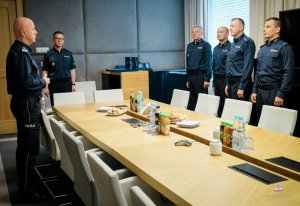 Komendant Główny Policji, Dyrektor Gabinetu KGP i policjanci z Buska Zdroju stoją w mundurach w sali odpraw