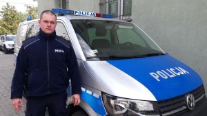 post. Łukasz Radzewicz z łódzkiej Policji stoi przy radiowozie