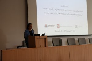 Kobieta przemawia do uczestników konferencji stojąc za mównicą