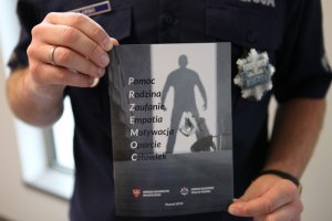 Policjant trzyma ulotkę