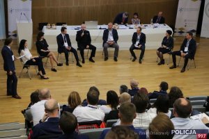 zaproszenie goście na forum siedząc na krzesłach przed widownią rozmawiają podczas ogólnopolskiej konferencji eksperckiej pn. „System Poszukiwań Osób Zaginionych - wyzwania XXI wieku” w związku z Międzynarodowym Dniem Dziecka Zaginionego