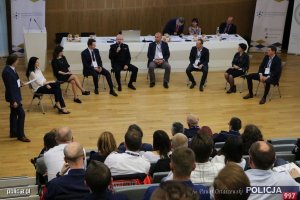 zaproszeni goście na forum siedząc na krzesłach przed widownią rozmawiają podczas ogólnopolskiej konferencji eksperckiej pn. „System Poszukiwań Osób Zaginionych - wyzwania XXI wieku” w związku z Międzynarodowym Dniem Dziecka Zaginionego