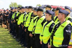 Na zdjęciu oddział prewencji Policji. Funkcjonariusze stoją w zwartym szeregu słuchając przemówienia rozpoczynającego ćwiczenia